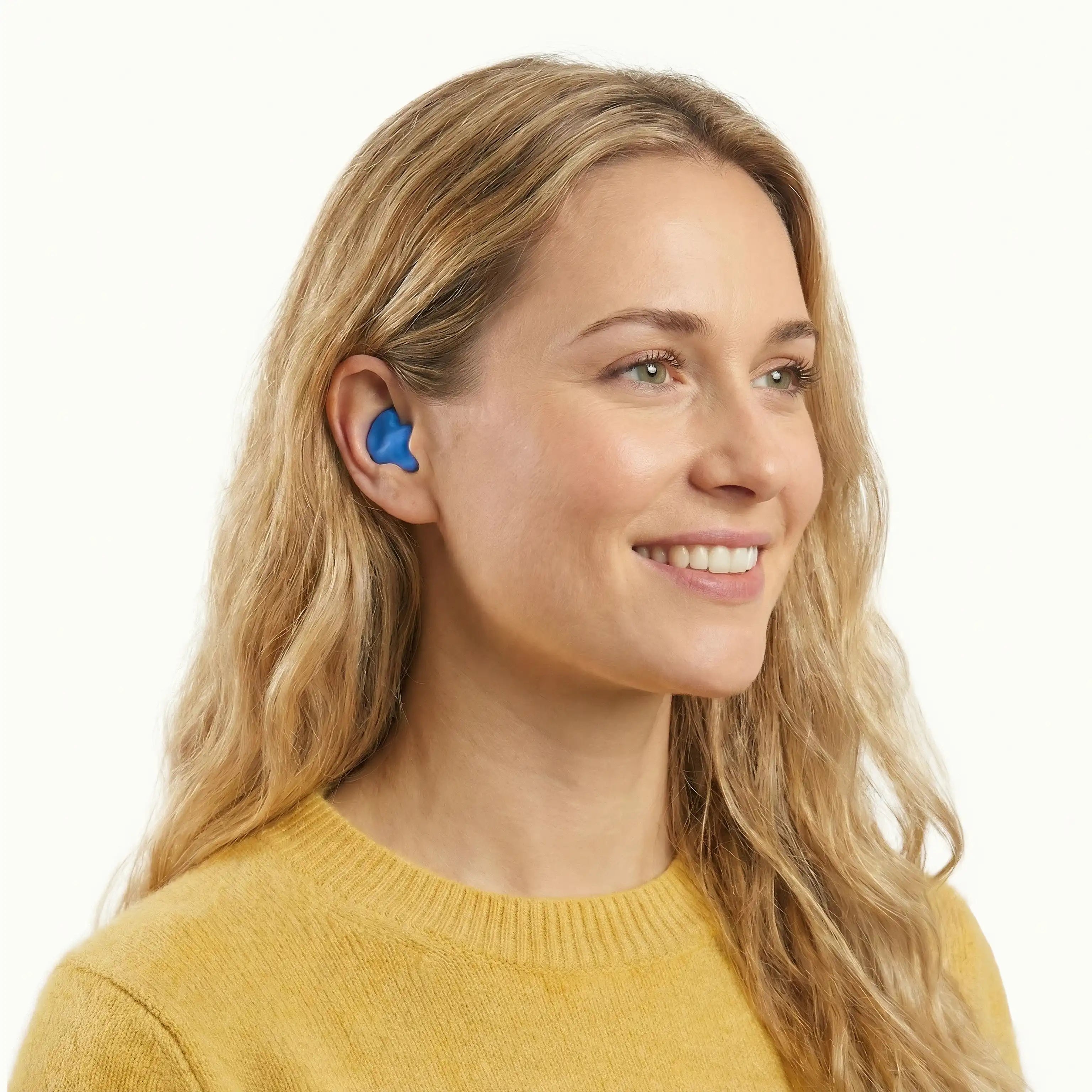 A blonde woman wearing a blue Soundbud earplug, demonstrating a soft silicone fit that prevents ear canal pressure and pain